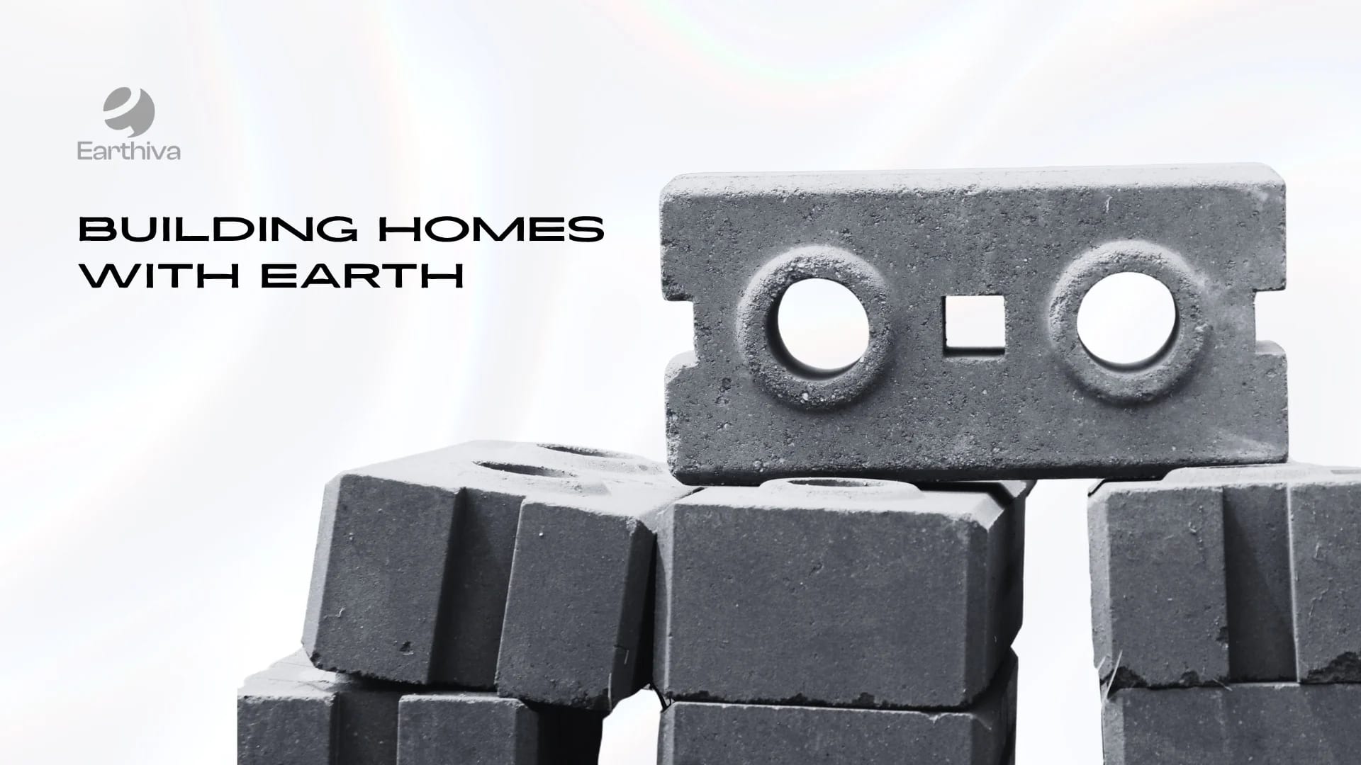 Earthiva blocks stacked and photographed in black and white, under the words Building homes with earth