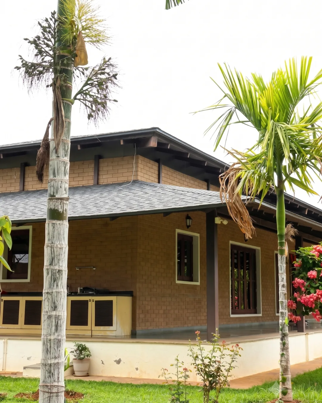 A guest block under a deep shingled roof, earth-block walls between timber windows