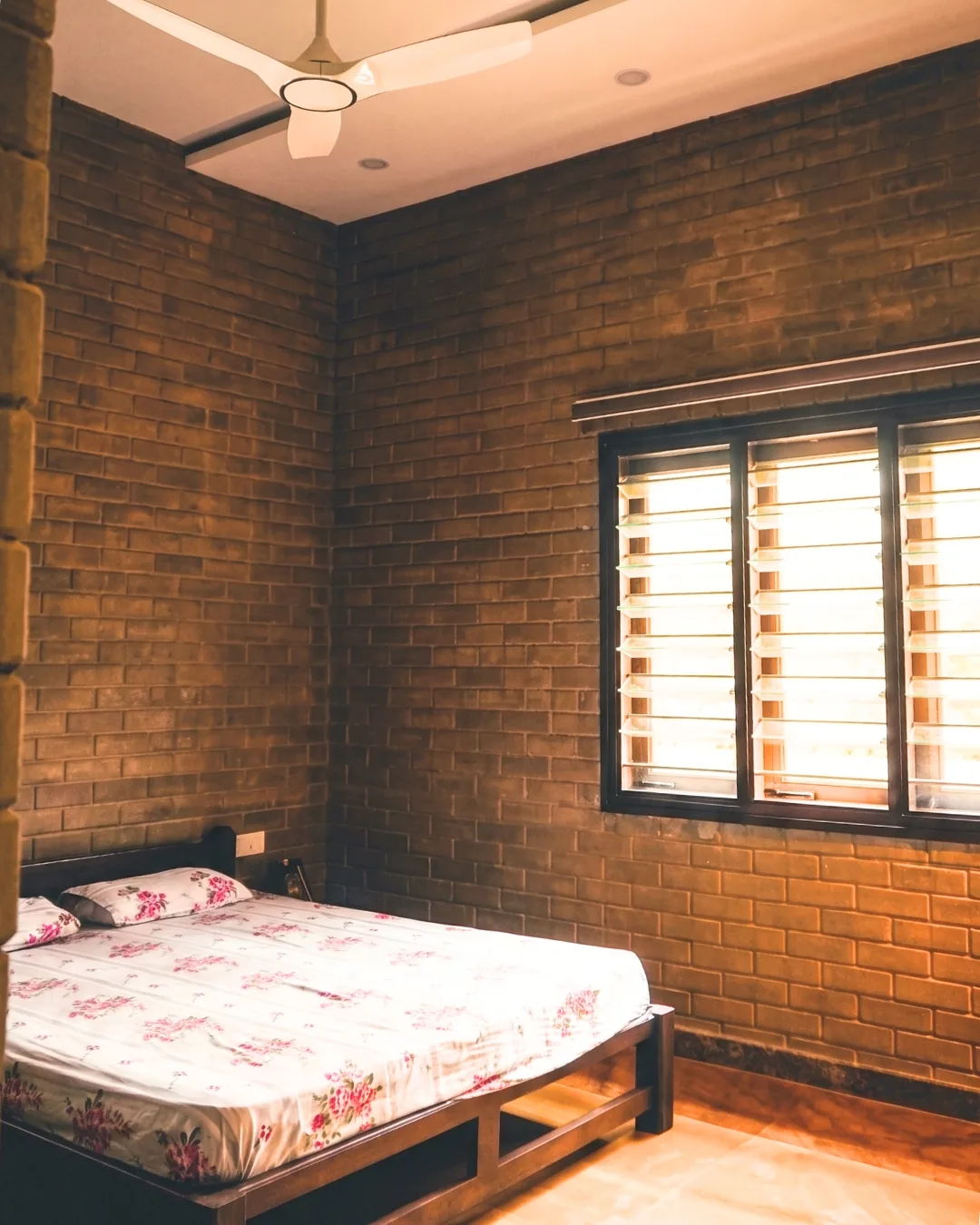 A guest bedroom walled on three sides in earth block